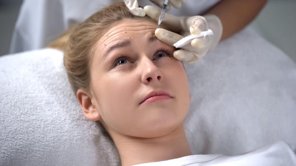 istock 1081762168 Cosmetologist making injection of botox to young woman, wrinkle smoothing
